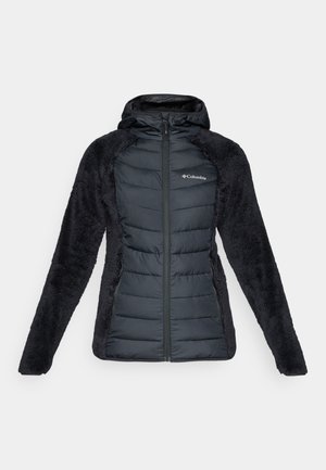 Casaco preto com capuz, apresentando uma frente acolchoada com seções matelassadas e mangas felpudas e texturizadas. O casaco tem um fecho totalmente zíper e um logótipo no peito.