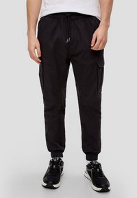 Czarne spodnie cargo z elastycznym spodem, tapered cuffs i bocznymi kieszeniami. Materiał jest lekki o gładkiej fakturze.
