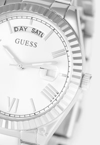 Silver stainless steel watch with a white dial, Roman numerals, and day-date feature. Includes a polished bezel and a classic bracelet design.