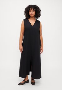 Black sleeveless dress made of soft fabric, featuring a V-neck, front slit, and a loose silhouette that falls to the ankles.