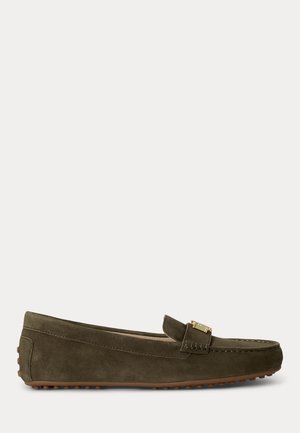 Mocassin en daim vert olive à enfiler avec semelle en caoutchouc marron effet galets et boucle métallique dorée sur le cou-de-pied.