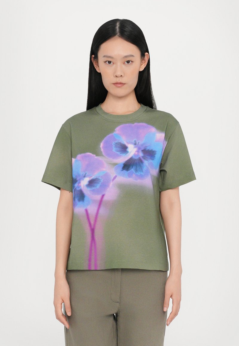 Olivgrünes T-Shirt mit kurzen Ärmeln, das mit großen blauen und lila Blumenmotiven bedruckt ist. Weicher Stoff mit lockerer Passform und Rundhalsausschnitt.