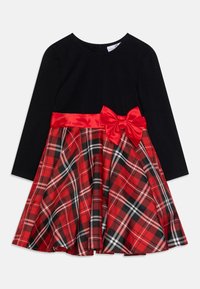 Zwarte jurk met lange mouwen en een rode geruite rok, een rode satijnen tailleband en een bijpassende strik op de taille, ontworpen voor kinderen.