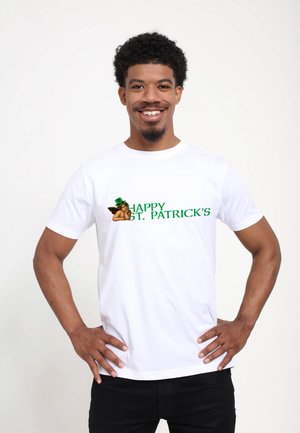T-shirt en coton blanc avec un texte vert qui dit « HEUREUX SAINT PATRICK » et un graphique d'un ange portant un chapeau vert sur le côté gauche.