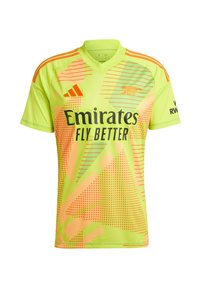 Neon vihreä jalkapallo-paita oransseilla yksityiskohdilla, jossa on V-kaula-aukko, geometrisia kuvioita, pilkullisia tekstuureja ja musta "Emirates Fly Better" -logo.