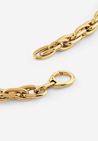 Gouden metalen armband met aan elkaar verbonden ovale schakels. Voorzien van een ronde sluiting voor veilige bevestiging, gepolijst met een reflecterend oppervlak.