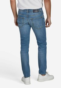 Lichtblauwe denim jeans met een slim fit, voorzien van een zwart label op de taille, vijf zakken en subtiele stiksels.