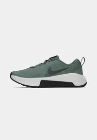 Nike spordijalats muted rohelises, millel on tekstureeritud pealis, mustad aktsendid, valge vaheosa ja kummist välistald selgelt väljendunud haardega.