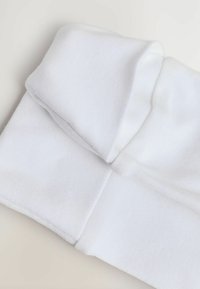 Weißer Baumwollstoff, der zu einem flachen Rechteck gefaltet ist, mit einer weichen Textur, einer sauberen, glatten Oberfläche und ohne sichtbare Muster oder Hardware.