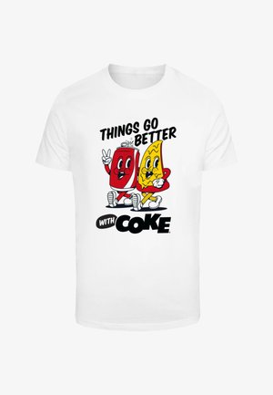 Camiseta blanca con un gráfico de una lata de bebida roja y un alimento amarillo, con el texto "LAS COSAS MEJORAN CON COKE" en fuente negrita negra.