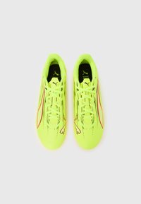 Limonkowo-zielone buty sportowe o teksturze, z czarnymi i czerwonymi akcentami oraz wyraźnym logo po obu stronach. Zawiązywki w komplecie.