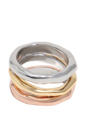 Tres anillos apilados de formas irregulares en metal plateado, dorado y oro rosa con superficies lisas y pulidas.