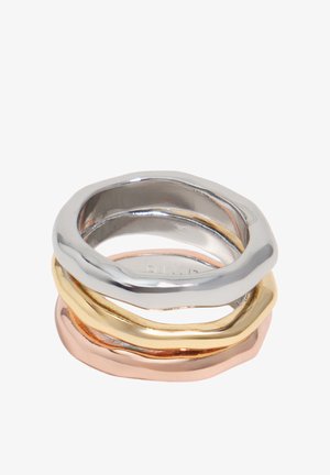 Tres anillos apilados de formas irregulares en metal plateado, dorado y oro rosa con superficies lisas y pulidas.