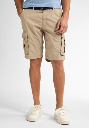 Beige cargo shorts with two side pockets and a straight cut. Worn with white sneakers. Lightweight fabric, casual design, and knee-length.