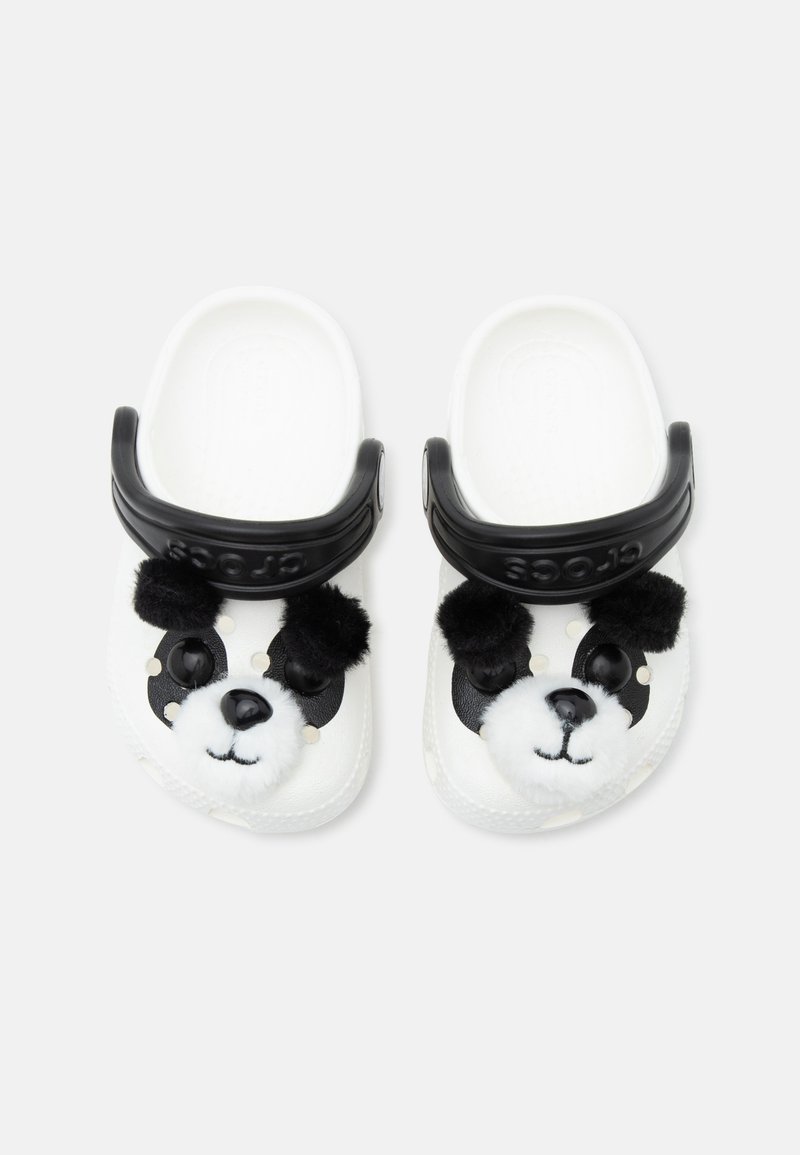 Chaussures blanches à enfiler avec des brides noires réglables, présentant un motif de visage de panda ludique avec des oreilles duveteuses et un nez sur le devant de chaque chaussure.