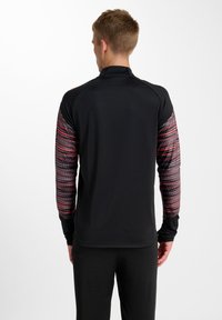 Långärmad träningsskjorta med svart kropp och mönstrade ärmar i rött och grått, med en figurnära design och hög krage.