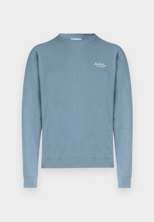 Helehall puuvillane pusa ümar kaeluse, pikkade varrukate ja soonikuga mansettidega. Rinnal on väike valge logo.