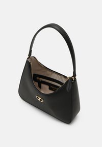 Sac à main en cuir noir avec fermeture éclair dorée et logo, ouvert pour montrer l'intérieur beige avec poche intérieure zippée et étiquette indiquant Twins Milano.