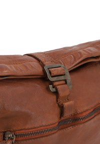 Brown leather handbag with a textured finish, featuring a metal buckle closure and a zippered pocket along the front.