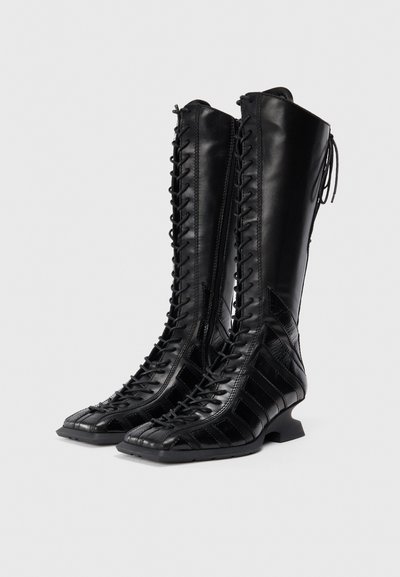 Black leather knee-high boots featuring a lace-up front, textured panels, and a small stacked heel. Smooth finish with contrasting accents.