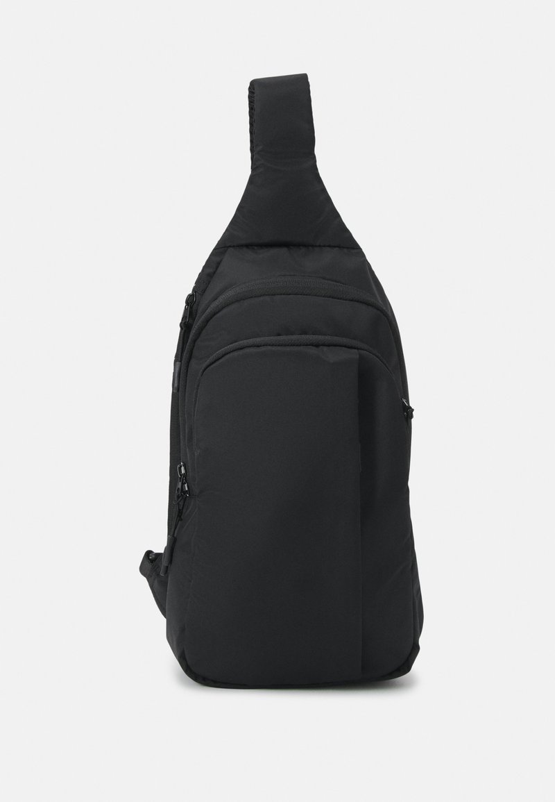 Černý látkový taška přes rameno s jedním popruhem, několika zipovými přihrádky a elegantním, minimalistickým designem.