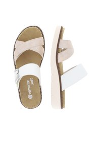 White and beige sandals with cross straps and adjustable buckle; soft footbed; lightweight rubber sole with textured grip.