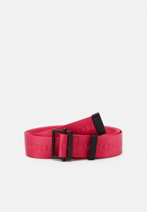 Ceinture en tissu rouge avec une boucle rectangulaire noire et une extrémité noire, posée à plat sur un fond blanc.