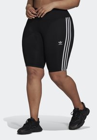 Black cycling shorts with a high waist, featuring white three-stripe design down the sides and small white Adidas logo on leg.
