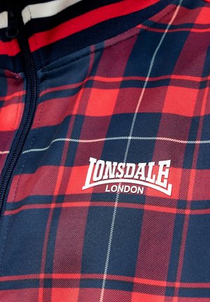 Red and navy plaid zip-up jacket featuring white "Lonsdale London" logo. Made of textured fabric with contrasting stripes on the collar.