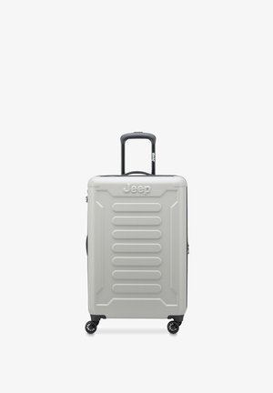 Valigia rigida Jeep di colore grigio chiaro, con scanalature verticali, manico telescopico nero e quattro ruote girevoli nere.