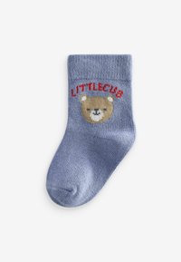 Blå strikket sok med et bjørnesymbol og teksten "LITTLECUB" i rød. Sokken har en ribbet kant og en blød tekstur.