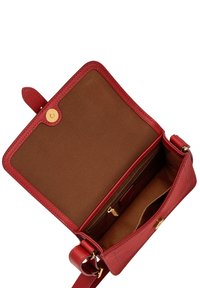 Sac à main en cuir rouge avec une fermeture à bouton-pression dorée. L'intérieur est doublé de tissu marron avec une poche zippée et des emplacements pour cartes. Texture lisse, forme rectangulaire.