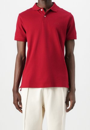 Rød polo shirt lavet af bomuld, med en tre-knaps placket, korte ærmer og et lille broderet logo på brystet.