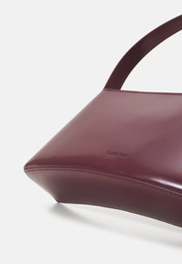 Calvin Klein REFINED SCULPT BAG SHINY - Geantă de mână - oxblood