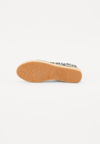 Sole di espadrilla con un design testurizzato e a motivi in marrone chiaro. Presenta un bordo in fibra naturale e un dettaglio del logo in rilievo al centro.