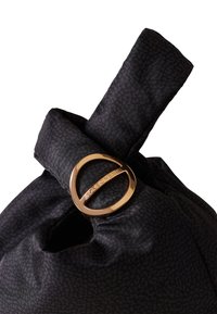 Black fabric bag with a subtle pattern, featuring a knotted top and a gold-tone circular hardware accent. Smooth texture, medium size.