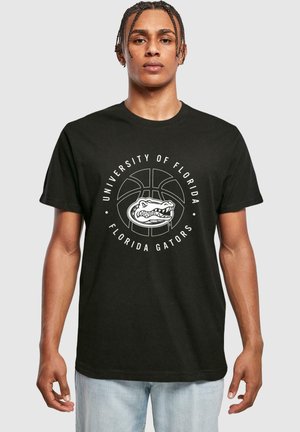 Fekete pamut póló, amelyen egy fehér grafikán kosárlabda és egy alligator látható, a "University of Florida" és a "Florida Gators" felirattal.