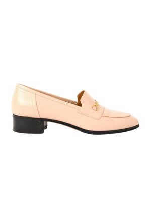 Mocassin en cuir rose clair à petit talon, semelle noire et petit emblème décoratif doré sur le devant.