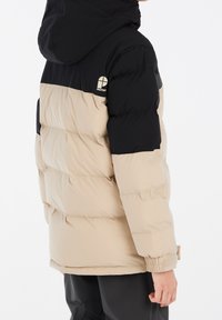Veste doudoune beige et noire avec capuche, présentant une texture matelassée et des poignets élastiques. Logo affiché sur le côté supérieur gauche.