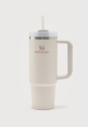 Hoge beige Stanley geïsoleerde mok met handvat, witte deksel en doorzichtige rietje, ontworpen voor warme of koude dranken.