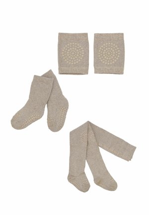 Calzini antiscivolo beige per bambini piccoli, collant e ginocchiere con motivi circolari antiscivolo disposti su uno sfondo bianco.