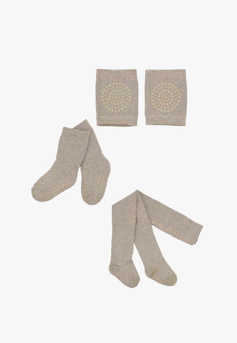 Beige rutschfeste Babysocken, Strumpfhosen und Knieschoner mit kreisförmigen Griffmustern, arrangiert auf weißem Hintergrund.