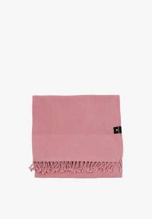 Zložený ružový látkový uterák s strapcami pozdĺž jedného okraja a malou čiernou etikietou pripevnenou na boku.