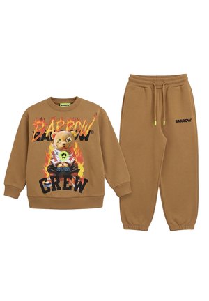 Sudadera color tostado y pantalón de chándal a juego con cordón; la sudadera muestra un osito de peluche entre llamas y un texto llamativo.