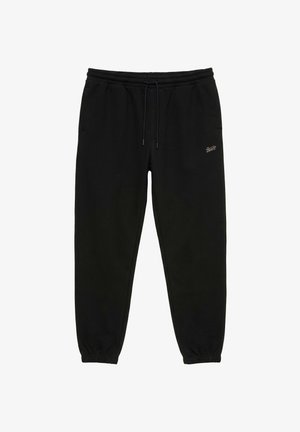 Pantalon de survêtement noir avec taille et poignets élastiques, cordon de serrage, poches latérales et petit logo sur la cuisse droite.