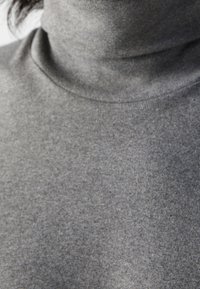 Grauer Rollkragenpullover aus einem weichen, strukturierten Stoff. Nahaufnahme, die den Kragen und die glatte Oberfläche mit leichten Farbnuancen zeigt.