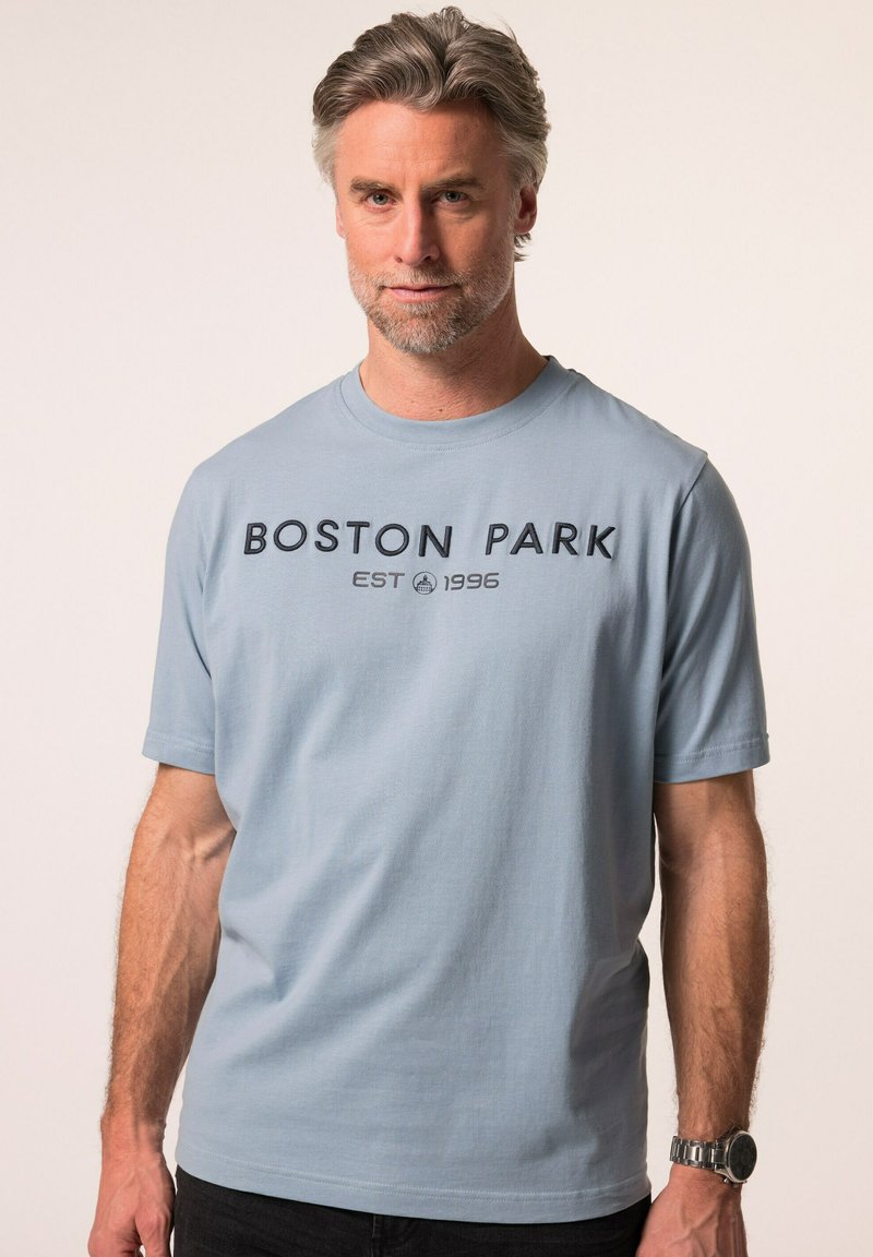 Hellblaues T-Shirt mit Rundhalsausschnitt aus Baumwolle, mit schwarzem Text "BOSTON PARK EST 1996" in der Mitte auf der Vorderseite. Kurze Ärmel, lockere Passform.