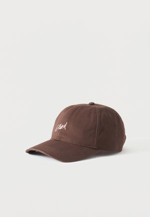 Braune Baseballkappe mit gebogenem Schirm und weißem kursivem Text auf dem Vorderteil, abgebildet vor schlichtem hellgrauem Hintergrund.