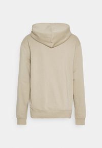 Sudadera beige con tejido texturizado, mangas largas y capucha con cordón. La parte posterior presenta una superficie lisa y continua.