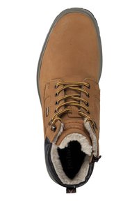 Botín de cuero marrón con acentos negros, puntera redonda, forro de piel texturizada y cordones amarillos. Presenta ojales de metal y suela de goma.